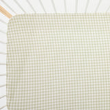 Green and white checkered crib sheet on a crib